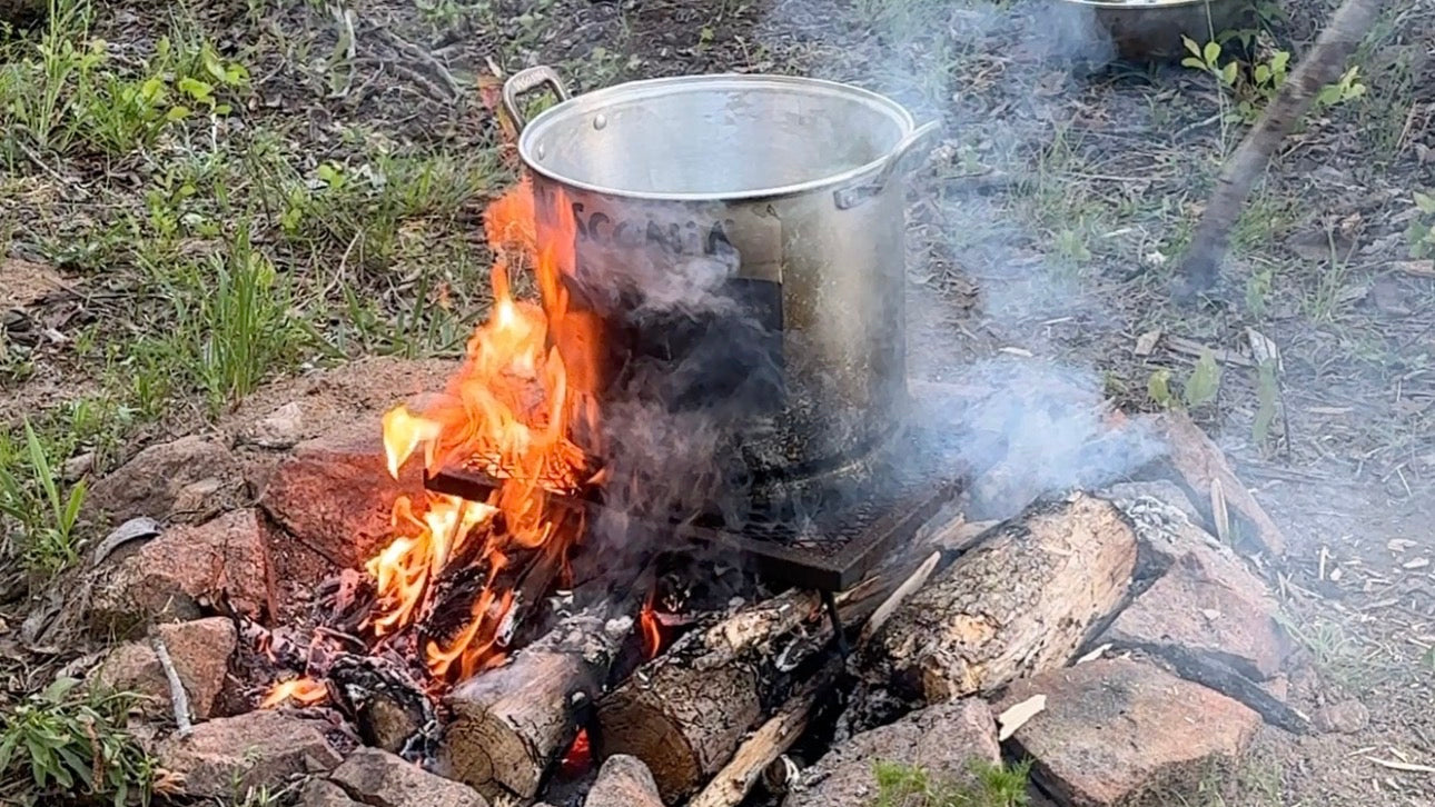 Metal pot over a campfire in an outdoor setting