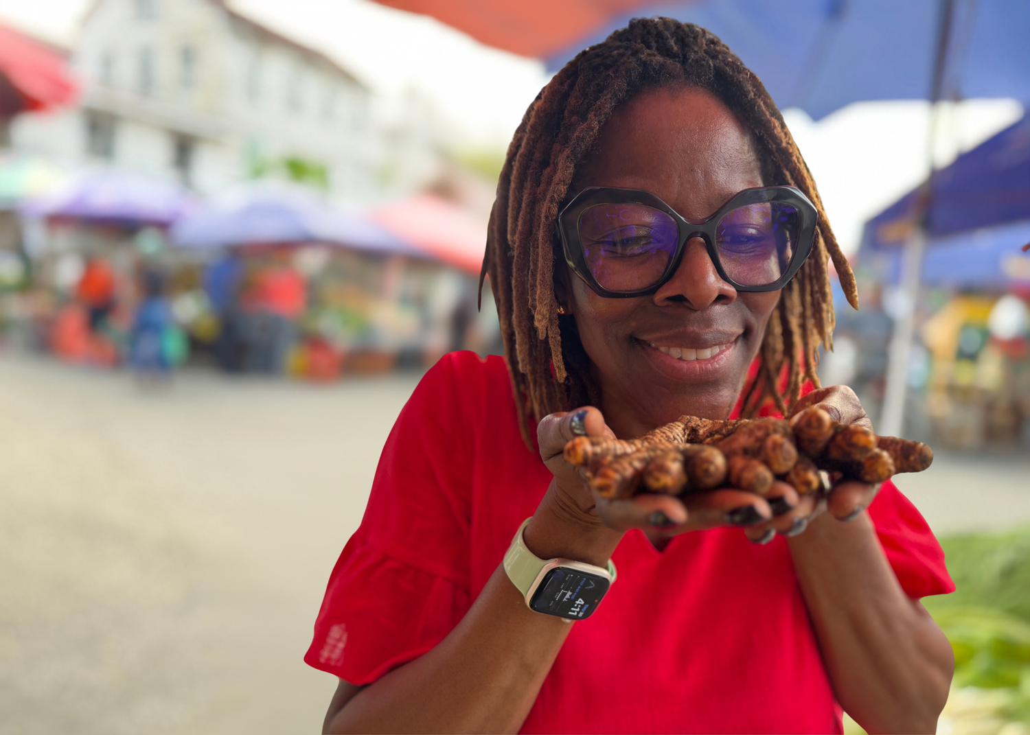 Person holding a chocolate pastry in an outdoor market setting