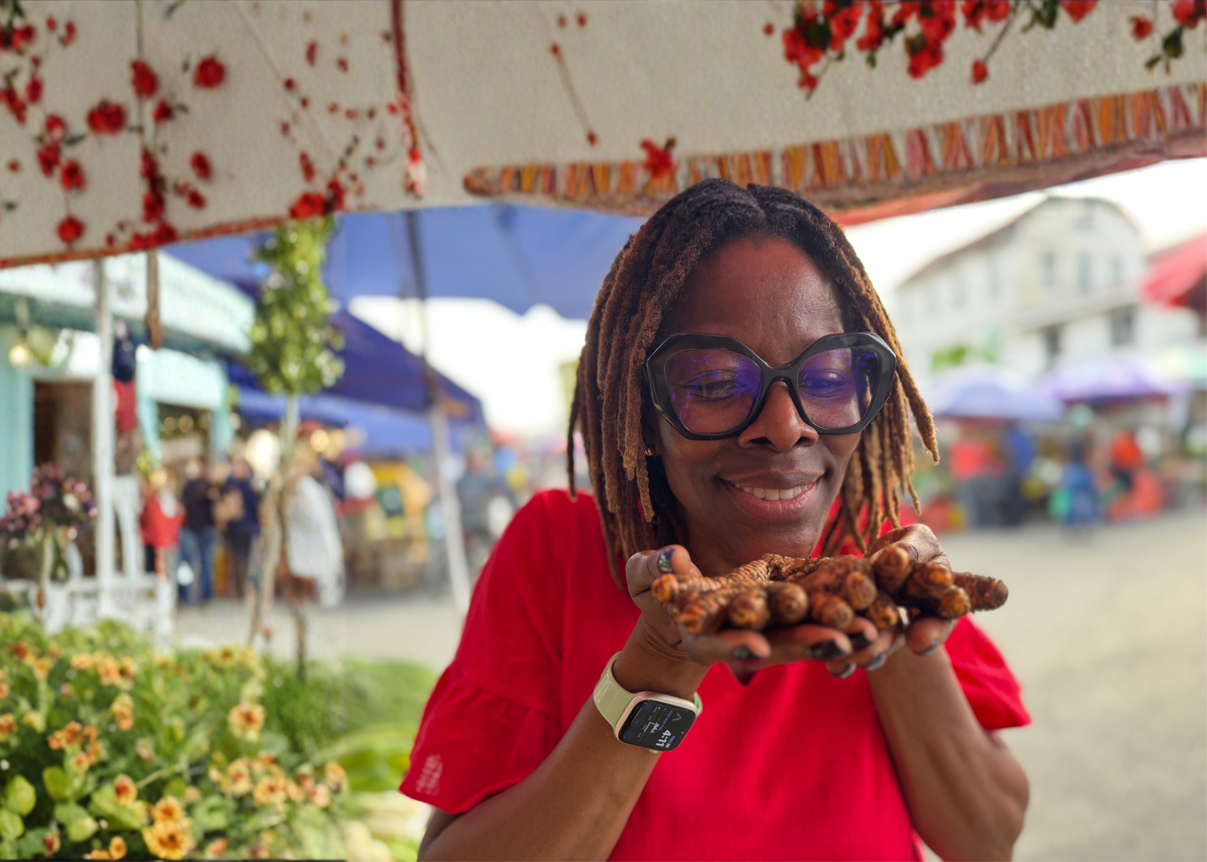 Person holding roasted plantains in a market setting